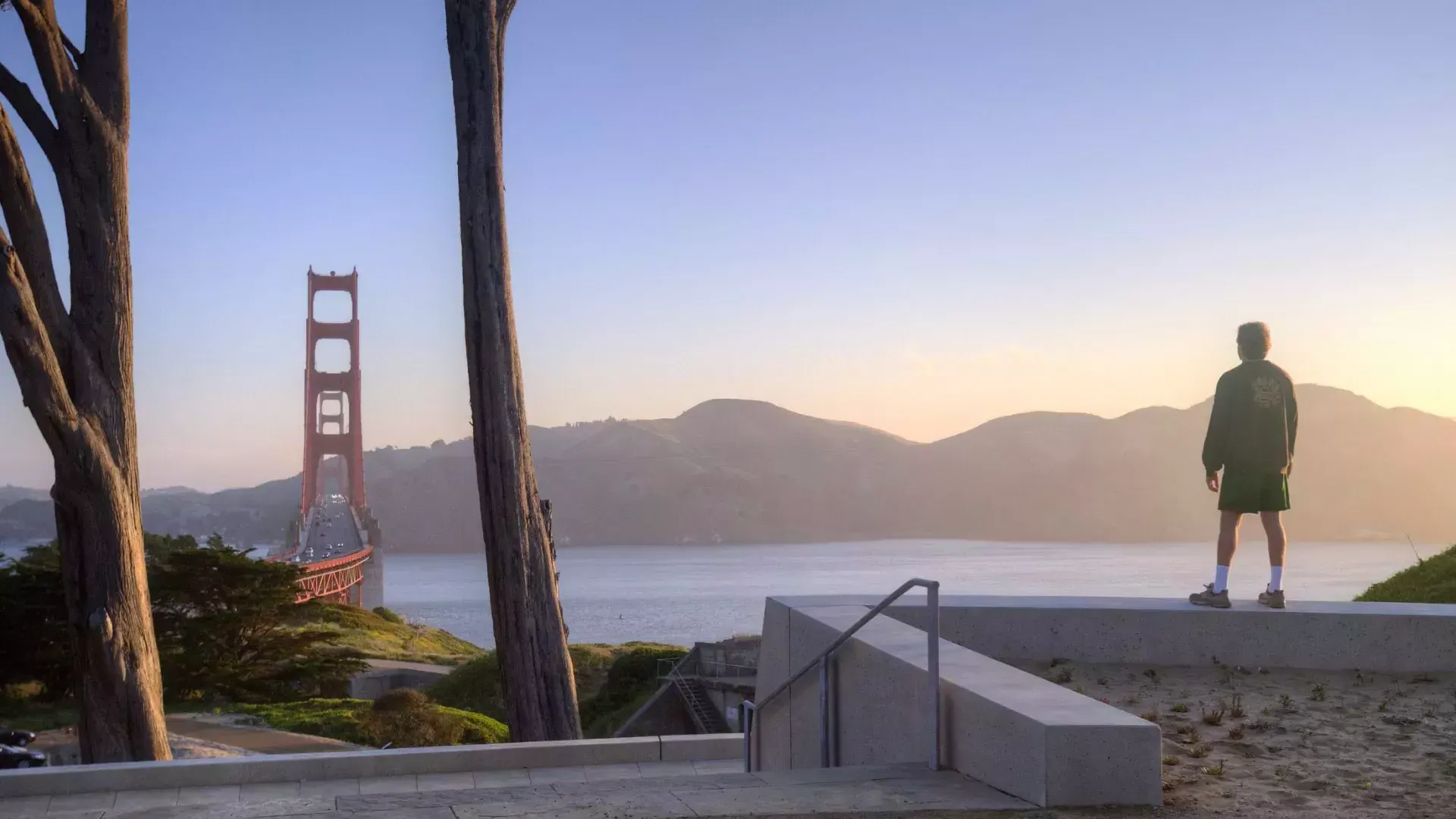 男性が山々を背景にGolden Gate Bridge見下ろしている。